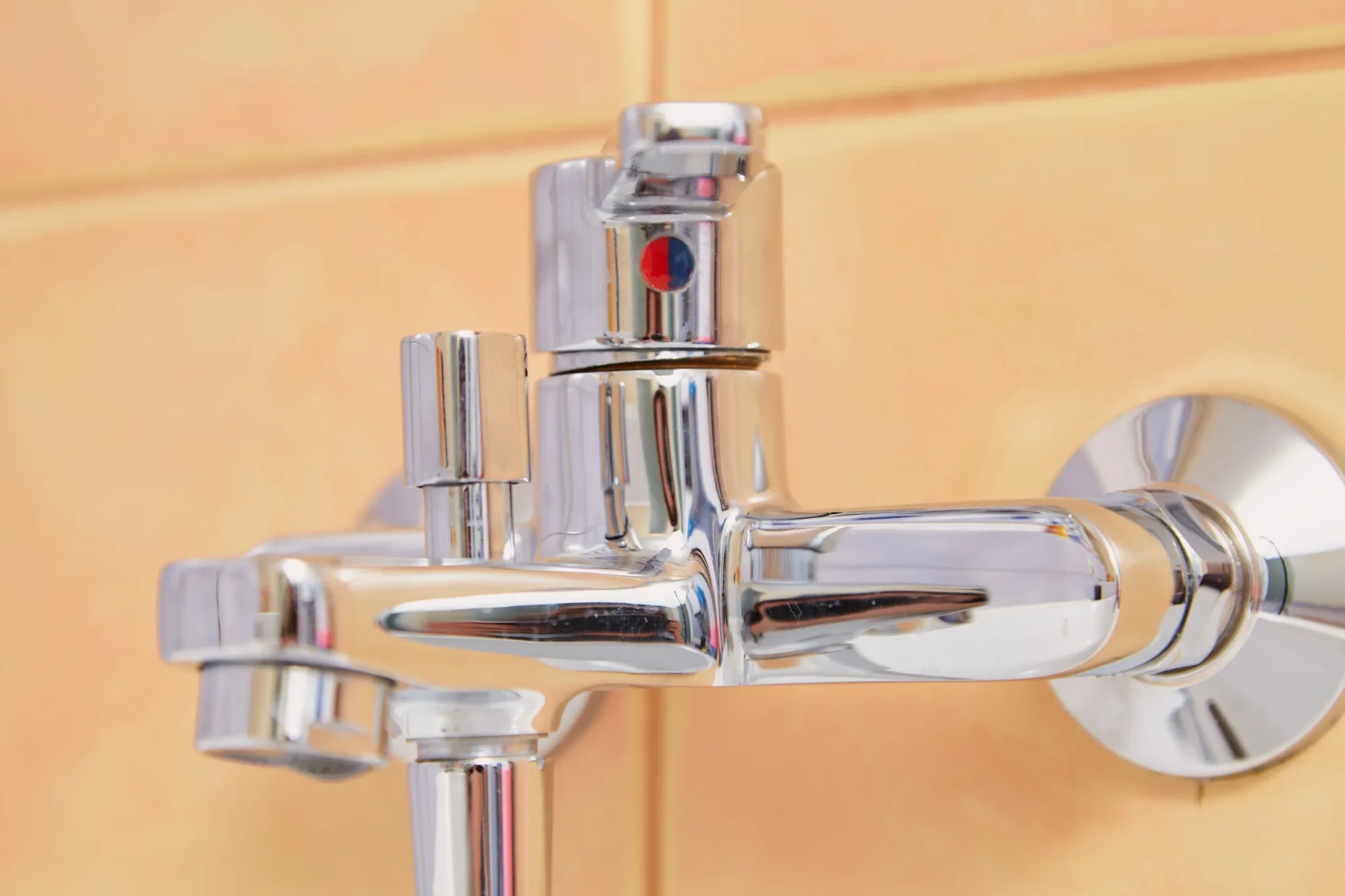 Chrome bathroom faucet on tiled wall.